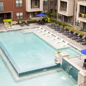 Resort style pool with lounge chairs and outdoor dining