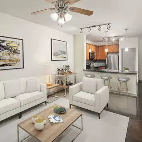 Open concept living area with ceiling fan track lighting and concrete flooring