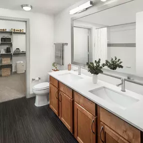 Bathroom with two sinks and walk-in closet at Camden Design District apartments in Dallas, TX