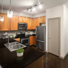 Kitchen with granite countertops stainless steel appliances and concrete flooring