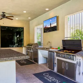 Two barbecue grilling stations with tv ceiling fans island seating and granite countertop