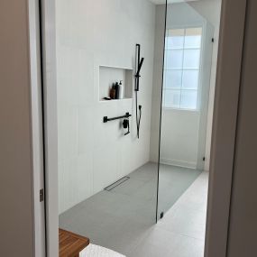 Beautiful bathroom remodel that involved expanding and enlarging the bathroom. The tile selection helped to lighten the overall appearance and contrasts beautifully with the dark fixtures.