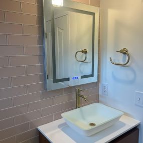 Installed vessel sink, lighted mirror and new tile wall in this beautiful bathroom remodel!