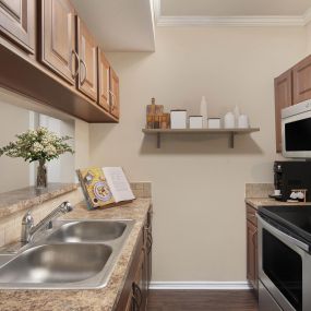 Kitchen with stainless steel appliances and bar-height countertop at Camden Legacy Creek