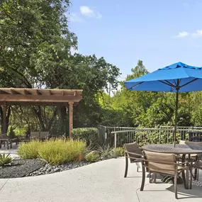 Poolside covered patio and table at Camden Legacy Creek apartments in Plano, TX