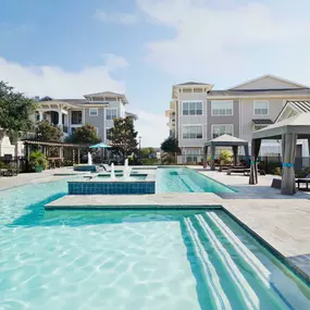 Swimming pool with lounge chairs and water feature at Camden Northpointe in Tomball, TX