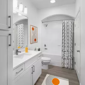 Bathroom with white cabinetry, white quartz countertops, large soaking bathtub and stand up shower at Camden Northpointe apartments in Tomball, TX.