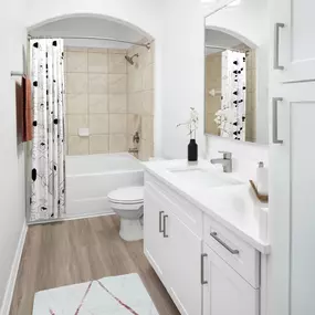 Bathroom with white cabinetry, white quartz countertops, large soaking bathtub and stand up shower at Camden Northpointe apartments in Tomball, TX.