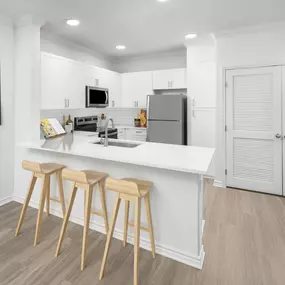 Kitchen with white quartz countertops and breakfast bar at Camden Northpointe Apartments in Tomball, Tx