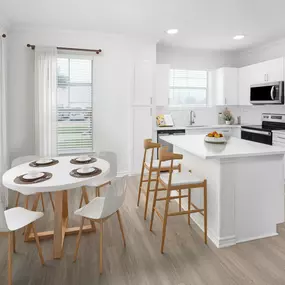 Kitchen with white quartz countertops, stainless steel appliance and dining room at Camden Northpointe Apartments in Tomball, Tx