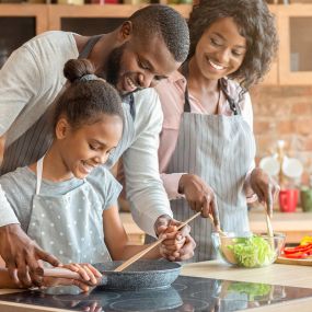 A happy family cooking together after successful family counseling