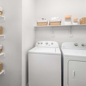 Laundry room and pantry with built-in shelves and full size washer and dryer at Camden Stoneleigh apartments in Austin, TX.