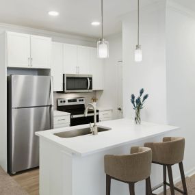 Renovated kitchen with white cabinets and white countertops at Camden Stoneleigh apartments in Austin, Tx