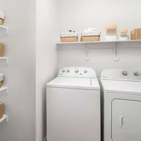 Laundry room and pantry with built-in shelves and full size washer and dryer at Camden Stoneleigh apartments in Austin, TX.