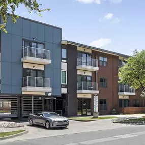 Building exterior showing private balconies and gated parking entrance at Camden Henderson apartments in Dallas, TX