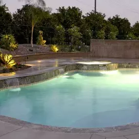 Custom inground pool at night with pool lighting