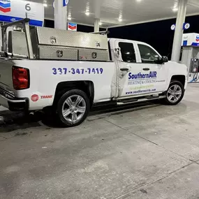 Tim's Southern Air Heating, Cooling & Plumbing work truck near gas station