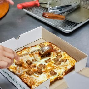 Saucing Detroit Deep Dish Pizza