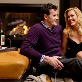 XV Beacon, a luxury Hotel in Boston. Image of couple in front of fireplace with chocolate covered strawberries.
