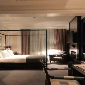 XV Beacon, a luxury Hotel in Boston. View of a spacious hotel room with ambient lighting and large windows.