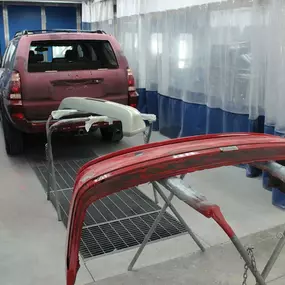 The photo shows a vehicle in the process of being repaired and painted at Ball Body Shop