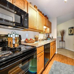 Gourmet Kitchens with G.E. Black Appliances and Maple Raised-Panel Cabinetry at Pointe Royal Townhome Apartments