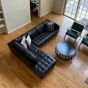 Open living room with leather sectional, shelves, and natural light at Clearview’s gender-inclusive mental health program.