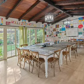 Bright art therapy room with large windows, colorful artwork, and creative supplies.