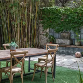 Outdoor table and chairs beside a calming fountain, in the women’s mental health treatment area at Clearview.