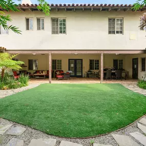 Spacious outdoor courtyard with trees and open space, used for yoga, mindfulness, and client connection in Venice Beach, California.