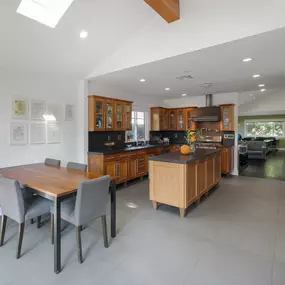 Modern kitchen and dining area with wooden cabinets and table, part of Clearview’s dual diagnosis residential housing.