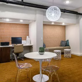 Business center with computers and arm chairs. A table with chairs