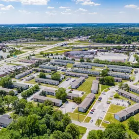 Aerial view of The Park at Greenhill apartment community in West Indianapolis. This expansive drone shot captures the full layout of the apartment buildings, townhomes, open green spaces, and surrounding infrastructure, showcasing the community’s proximity to major highways, retail centers, and mature wooded areas.