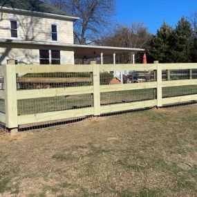 split rail fence with wire mesh behind