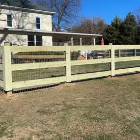 split rail fence with wire mesh behind