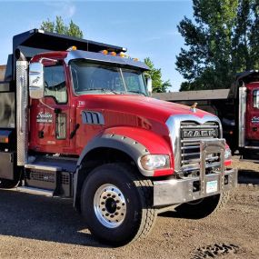 Two red Mack Granite dump trucks sold by RDO Truck Center in Fargo, ND.