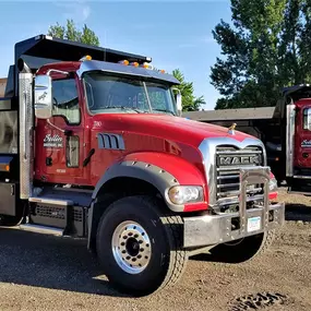 Two red Mack Granite dump trucks sold by RDO Truck Center in Fargo, ND.