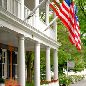 American flags handing over the entrance to a quaint inn