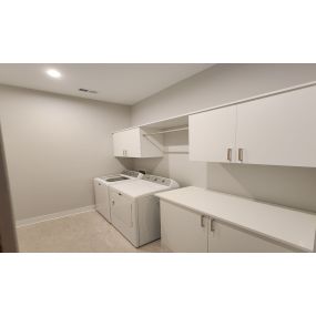 This laundry room organization was maximized with custom cabinets, countertop and hanging section.