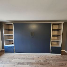 Convenient murphy bed with side tower storage in a lively color.