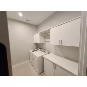 This laundry room organization was maximized with custom cabinets, countertop and hanging section.