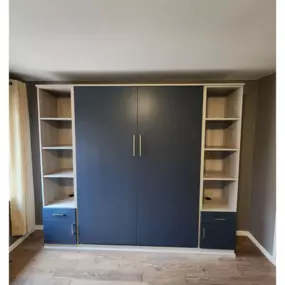 Convenient murphy bed with side tower storage in a lively color.