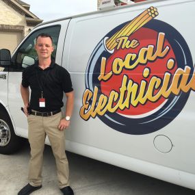 A Local Electrician technician standing in front of their van with the logo on the side