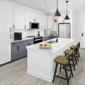 Two-bedroom spacious kitchen with quartz countertops and shaker-style cabinetry.