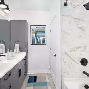 Bathroom with Quartz Countertops, Grey Cabinetry, Soaking Bathtub with Marble Style Surround