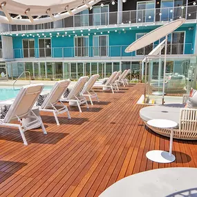A poolside deck with sun loungers and a table
