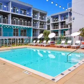 A large swimming pool in front of a multi-story apartment building