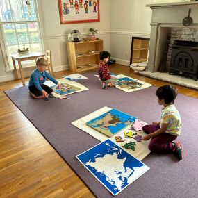 Children learning with map puzzles at Avalon Montessori.