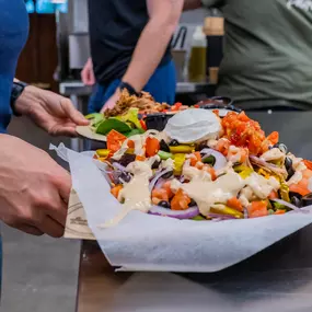 Loaded with cheddar and queso cheese, Kalua pulled pork, red & green onions, tomatoes, jalapeños & black olives – topped off with sour cream & mango salsa.