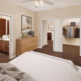 Bedroom with ensuite, walk-in closet and wood-style flooring at Camden Addison